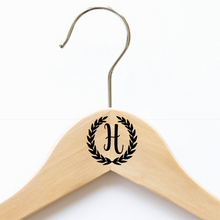 A coat hanger with a personalised monogram decal. Custom-made